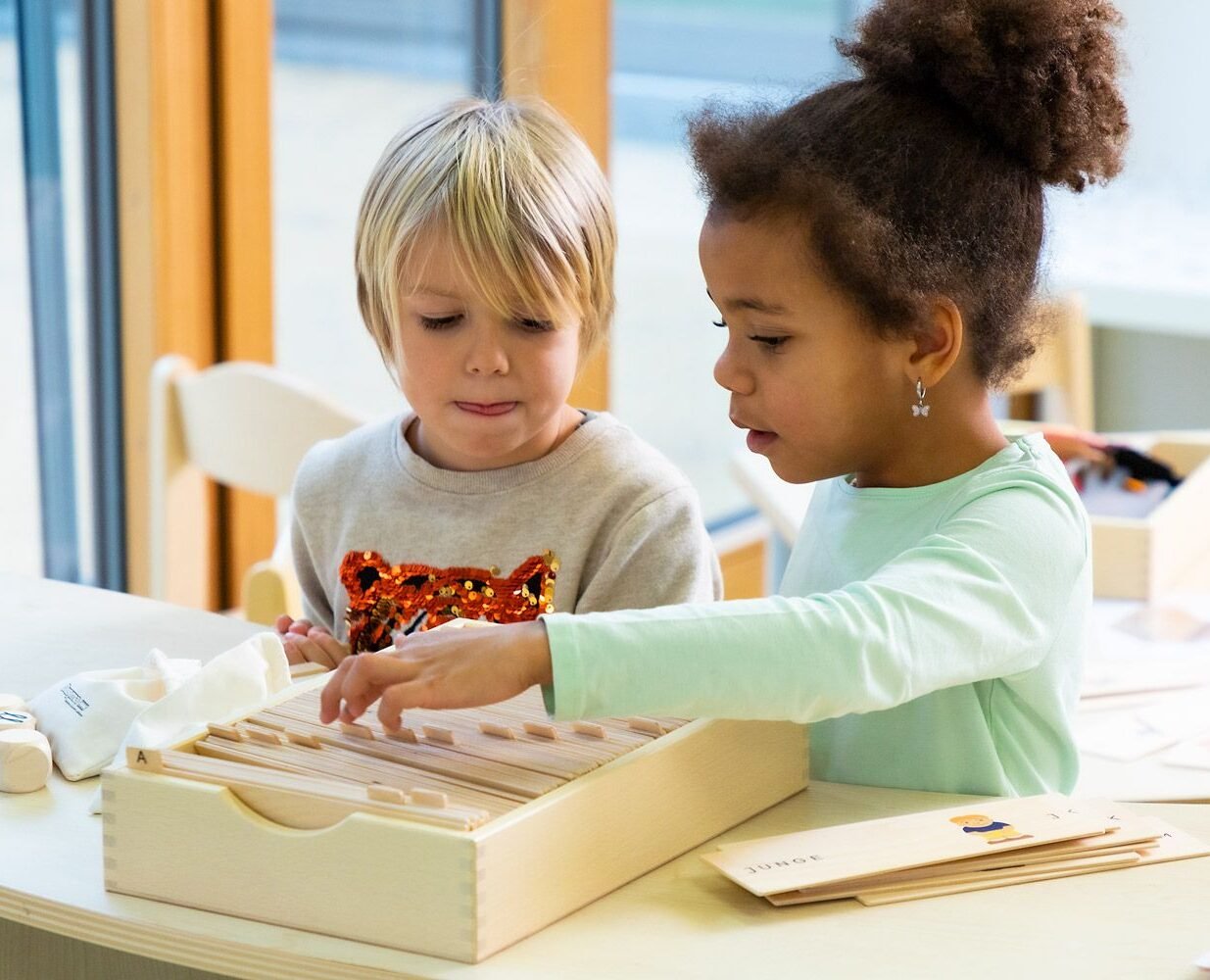 Child engaging in an activity that promotes phonological awareness and auditory perception.