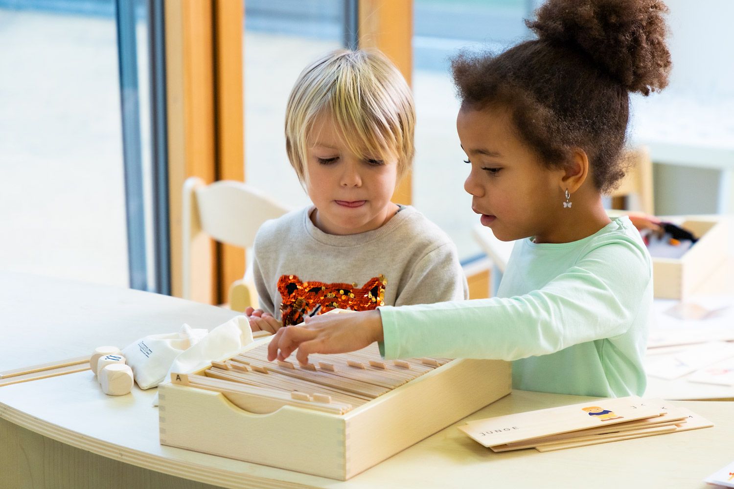 Child engaging in an activity that promotes phonological awareness and auditory perception.